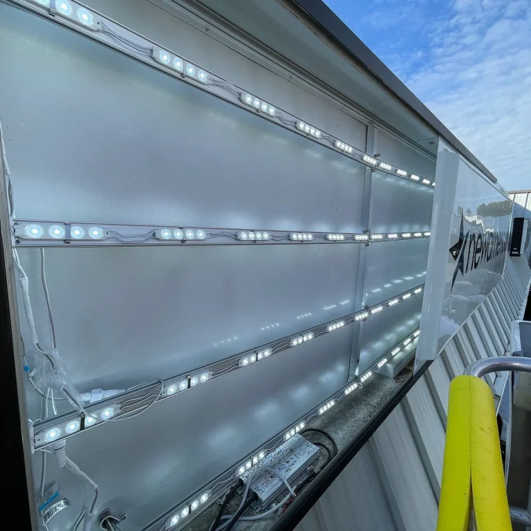 Close-up view of LED lighting module wiring inside a channel letter sign during installation.