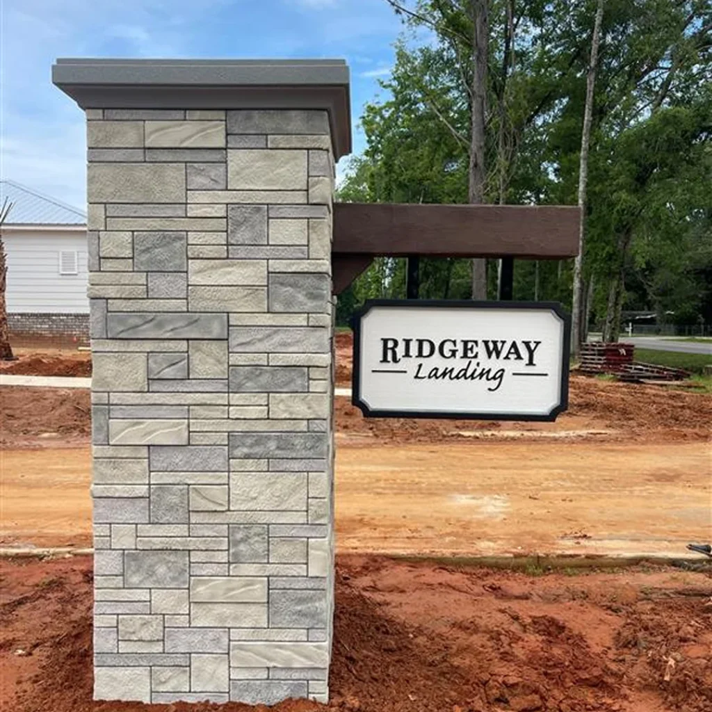 Newly constructed stone monument sign with a Ridgeway Landing hanging panel, completed by Vintage Sign & Light.