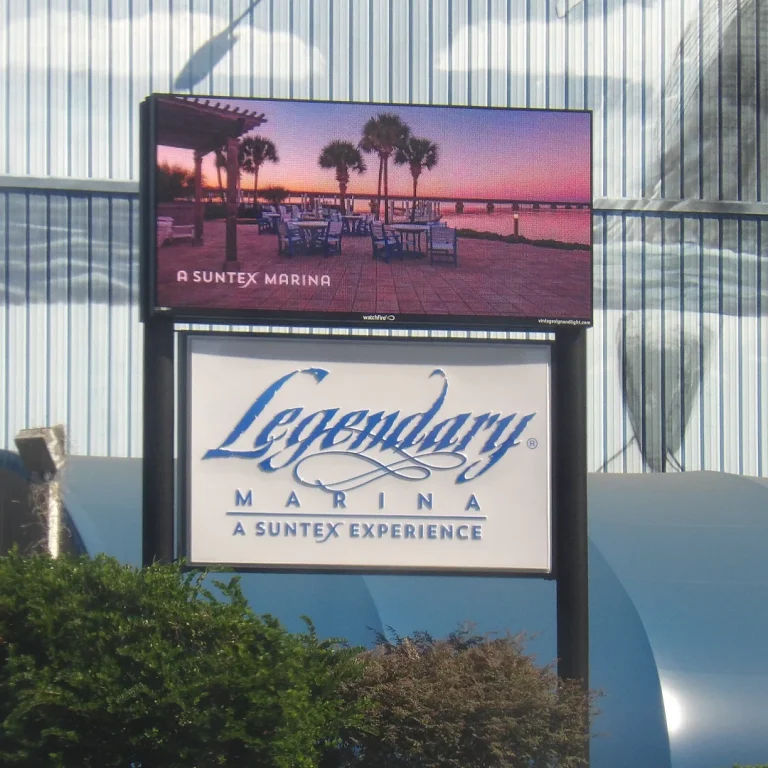 Watchfire LED display showing a sunset marina scene with palm trees above the Legendary Marina sign, installed by Vintage Sign & Light.