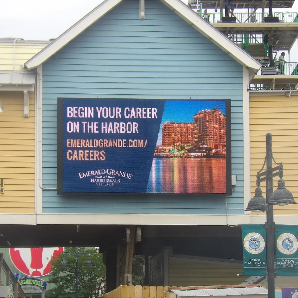 Large Watchfire LED screen mounted on a wall showing career ad for Emerald Grande at HarborWalk Village.