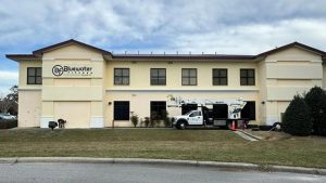 Bluewater Fitness sign installed on a commercial building with a sign service truck positioned at the site.