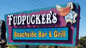 Fudpucker’s Beachside Bar & Grill monument sign with large dimensional lettering and a pelican graphic.
