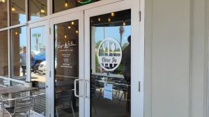 Restaurant entrance with custom window and door graphics including a Dine In graphic and business information.