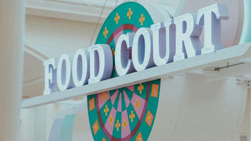 Retail Store Display Signs for a food court featuring large dimensional letters with colorful circular graphics in the background.