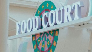 Retail Store Display Signs for a food court featuring large dimensional letters with colorful circular graphics in the background.