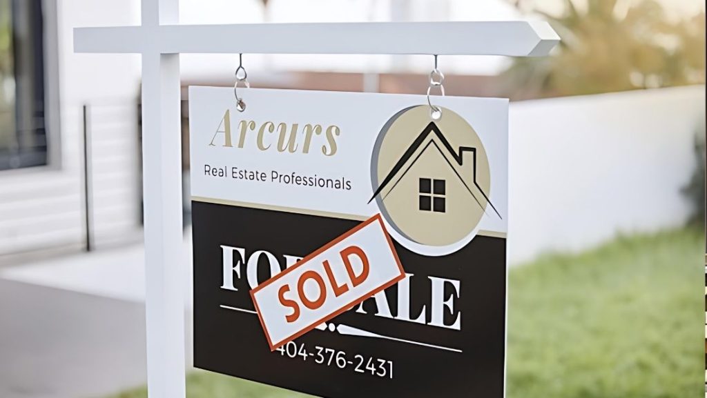 Close-up of a “Sold” real estate sign for Arcurs Real Estate Professionals hanging from a white post, created by a real estate sign company near me to promote recently closed property listings.