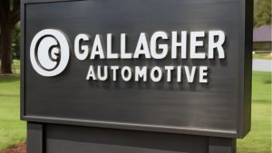 Gallagher Automotive logo displayed on sleek metal monument signs, featuring raised white lettering on a dark brushed metal background.