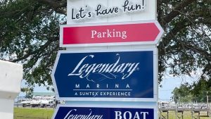 Multi tenant monument signs featuring Legendary Marina and Boat services with directional parking sign.