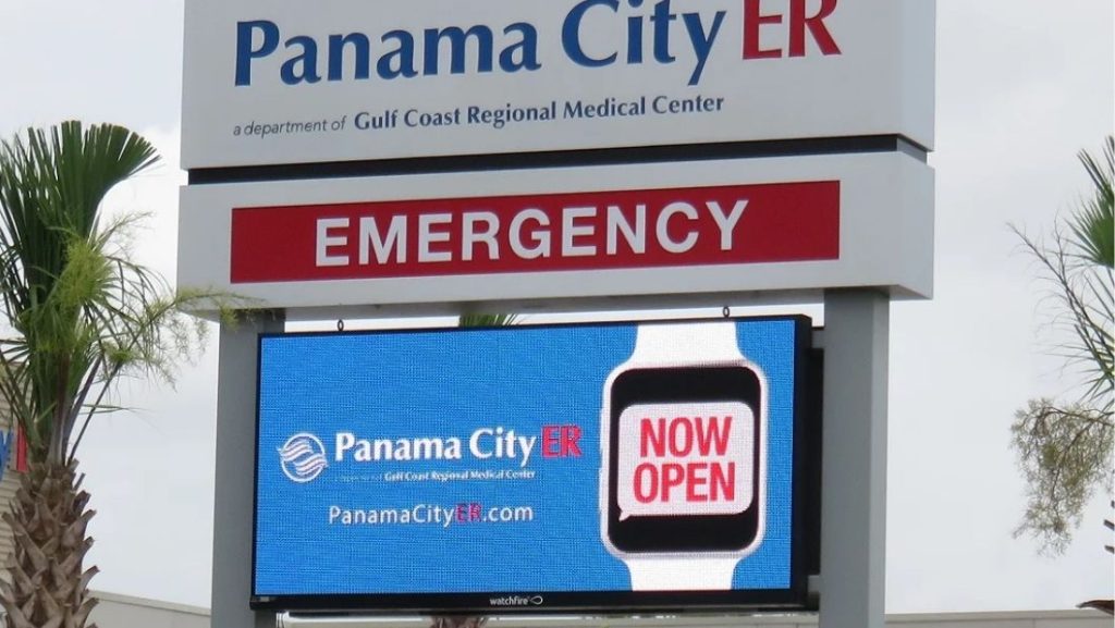 Digital signage providers showcase a 'NOW OPEN' message for Panama City ER on an electronic display, enhancing visibility and communication for emergency services.