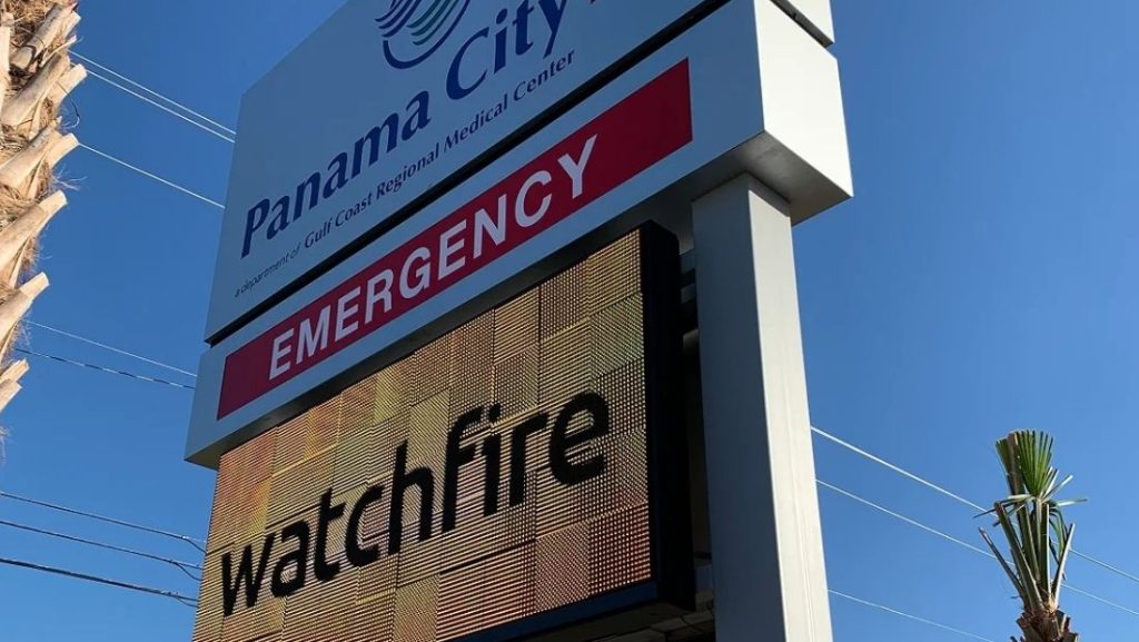 Digital signage providers display 'EMERGENCY' message on a bright electronic screen at Panama City Gulf Coast Regional Medical Center, enhancing visibility for urgent care information.