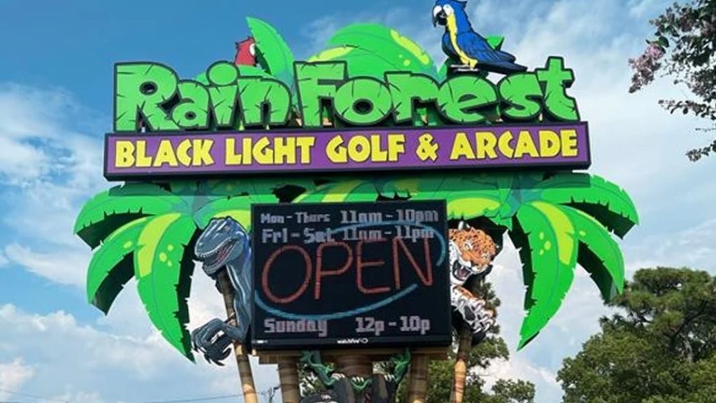 Digital signage near me for Rain Forest Black Light Golf & Arcade showing hours and "OPEN" sign.