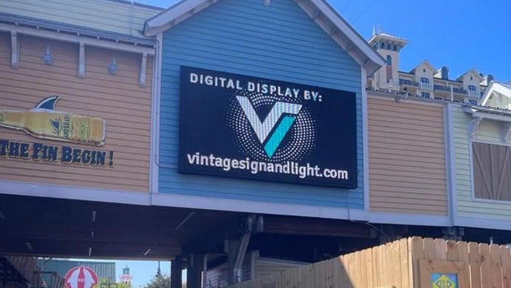 A digital signage near me display by Vintage Sign and Light on a blue and tan building.