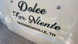 Cursive boat lettering displaying “Dolce Far Niente” with Hendersonville, TN on the back of a boat