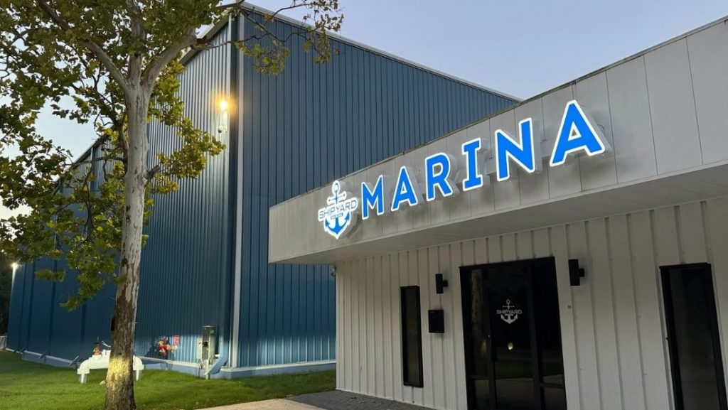 A professionally installed illuminated marina sign on a commercial building, showcasing a modern pylon sign, one of the various types of signs used for business visibility and branding.
