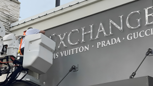 Installer mounting dimensional letters on a commercial building from a bucket lift.