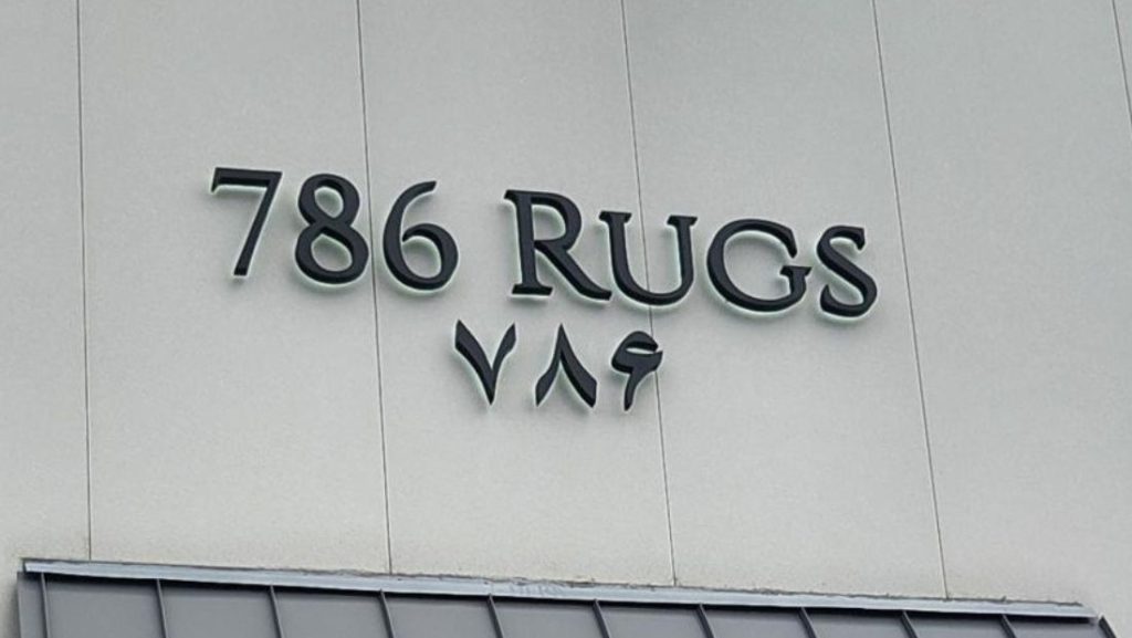 what are channel letters: exterior storefront sign reading “786 Rugs” with individual raised channel letters mounted on a building facade