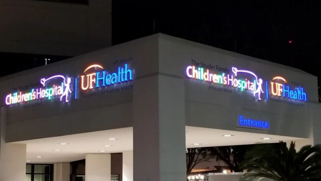 How are channel letters made: illuminated channel letters signage for UF Health Children’s Hospital with multi-color LED lighting mounted on a commercial building exterior at night