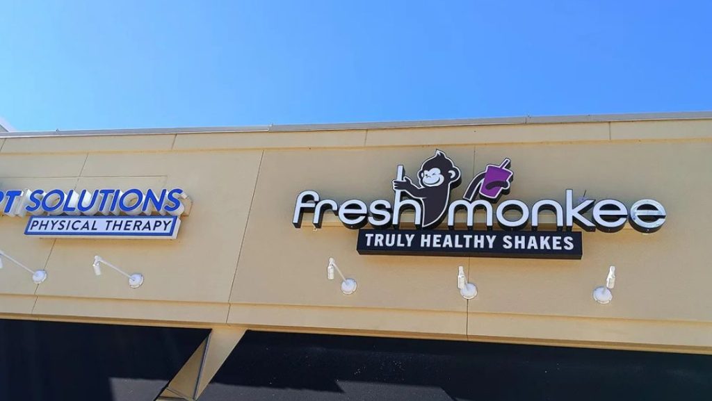 what are channel letters: illuminated storefront sign for “Fresh Monkee” with raised channel letters and logo mounted on a commercial building facade