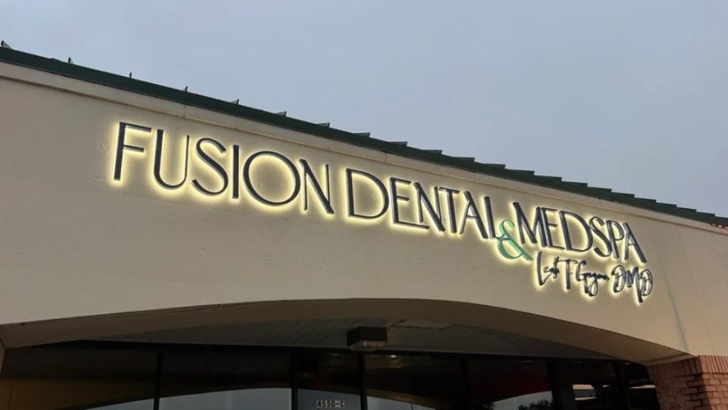 what are channel letters: halo-lit channel letter sign for “Fusion Dental & MedSpa” installed on a commercial building facade at dusk