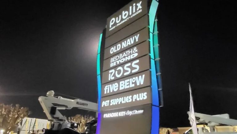 low angle view of illuminated shopping center monument sign at night