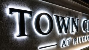 Close-up of LED-lit letters on a small monument sign reading 'TOWN CENTER', highlighting energy-efficient illumination and visibility at night.