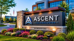 Custom illuminated monument sign with dimensional letters, stone columns, and landscaping at a corporate office entrance.