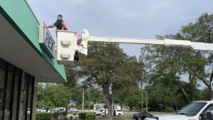 Vintage Sign & Light technician using a bucket truck to install an exterior business sign.