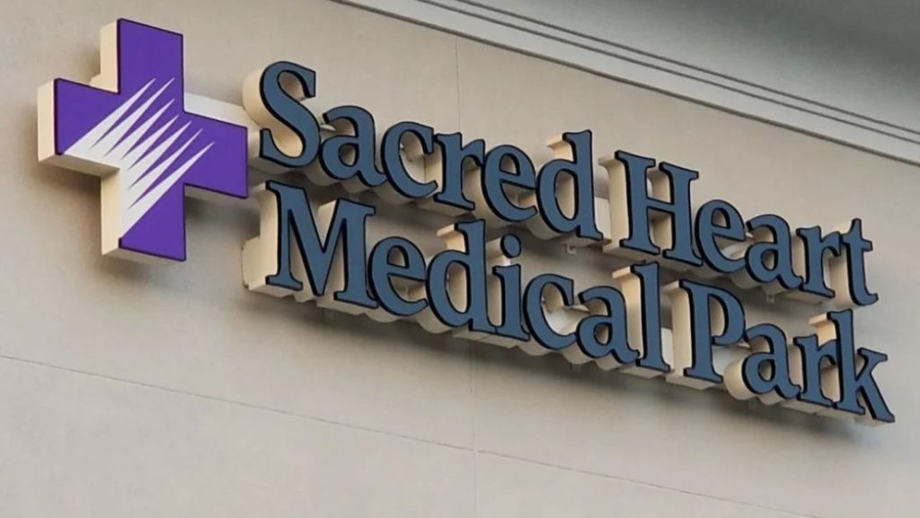Sacred Heart Medical Park channel letter sign with a purple medical cross on an exterior wall.