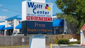 Watchfire digital display beneath the Wolff Center Pediatrics sign showing a "From Diapers to Degrees" message.
