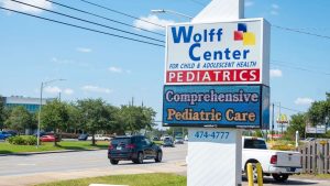 Monument sign with an outdoor LED display promoting pediatric healthcare services.