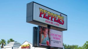 Restaurant monument sign with a Watchfire outdoor LED display promoting a weekly dining special.