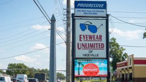 Monument sign with an outdoor LED display advertising a seasonal eyewear promotion.
