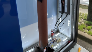 Open sign cabinet showing LED modules, power supplies, wiring, and internal components.