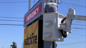 Vintage Sign & Light technician servicing an elevated digital pylon sign