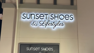 Illuminated Sunset Shoes & Lifestyles storefront sign in Destin, FL, featuring halo-lit lettering on the building facade.