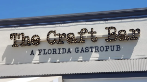 The Craft Bar building sign in Destin, FL, featuring illuminated marquee letters above the restaurant entrance.
